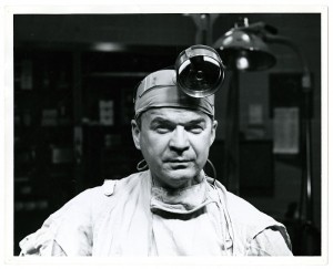 Photo of Dr. C. Walton Lillehei, wearing surgical scrubs and a head lamp.