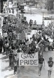 A photo of the 1973 Pride march in Minneapolis showing 100 people marching on Nicollet Mall led by a "Gay Pride" banner.