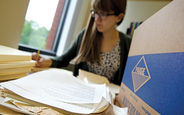 Library Assistant Kate Hujda processes a box of materials in the Performing Arts Archives.