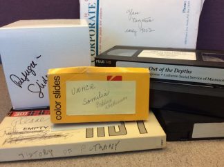 Photo showing the formats in the Lutheran Social Services Records including VHS video tapes, glass negatives and 3M reel to reel tape.