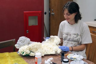 Art major and Wangensteen student employee, Hattie Matzdorf, makes coral for the display.