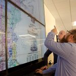 Ryan Mattke, Map & Geospatial Information Librarian, points out details on an 1871 map of Minnesota to Benjamin Wiggins, Program Director of the Digital Arts, Sciences, & Humanities (DASH) program.