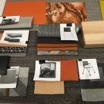 Photo of orange-themed fabric swatches and furniture finishes.