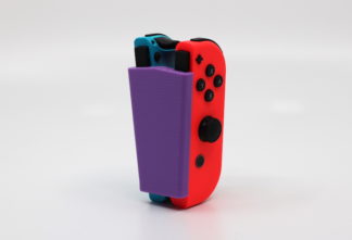Photo of 3D printed adaptive gaming device holding video game controller.