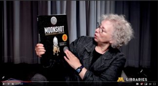 Lisa Von Drasek holding up the book "Moonshot"