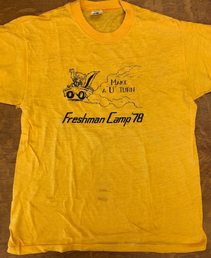 Yellow t-shirt with a cartoon drawing of Goldy Gopher driving a car with the text "Make a'U' turn Freshman Camp 1978."