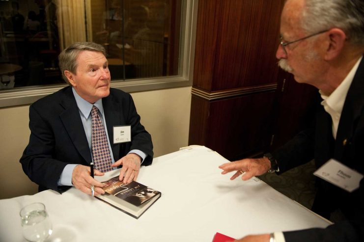 Jim Lehrer signing his book and engaging with a guest