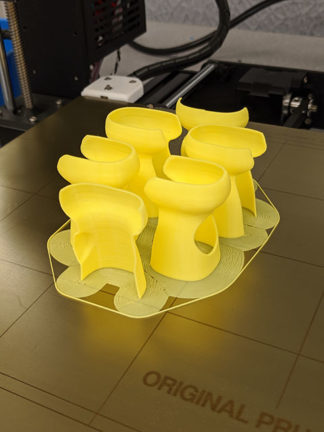 Ultrasound probe covers on the 3D printer bed, freshly printed with support structures intact.