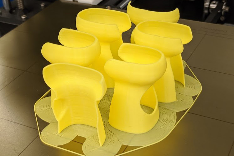 Ultrasound probe covers on the 3D printer bed, freshly printed with support structures intact.