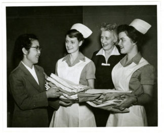This photograph features Director Katharine J. Densford of the University of Minnesota’s School of Nursing with Patricia Jaeger, President of the College Board of Nurses’ Dormitory and Marily Nelson, Vice president of the Student’s Nurses’ Association, presenting Mrs. Kwi Hyang Lee, Principle of Seoul National University’s School of Nursing with uniforms given to her Korean colleagues who are studying in the Nursing program at the University of Minnesota, in 1957. Mrs. Kwi Hyang Lee was one of the professionals from SNU who stayed in Minnesota for six months during which she was educated on nursing procedures and instructions, in which she could then apply at SNU. Source: University of Minnesota Archives, Photograph Collection.