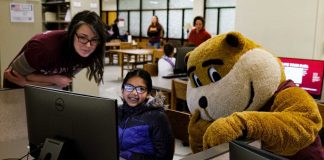 Alicia Kubas, left, and Goldy help out a student on History Day at Wilson Library.