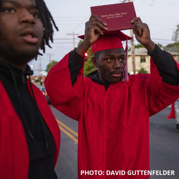 Photo by David Guttenfelder of two people in graduation gowns with one holding a diploma