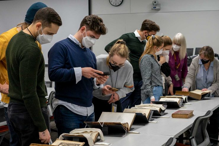 Heidelberg students examine rare books from the Wangensteen Historical Library of Biology and Medicine.