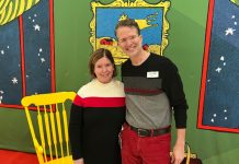 two people posing in front of the backdrop for the children's book "Goodnight Moon"