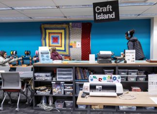 The Breakerspace at the Toaster, with a sign that says "Craft Island" hanging from ceiling. Counter with typewriter and craft supplies