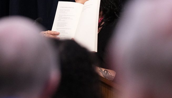 Sun Yung Shin holding up her book at the Pankake Poetry reading, 2023. Photo by Luke Logan