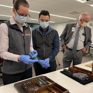 Students examine artifacts in a blood transfusion kit