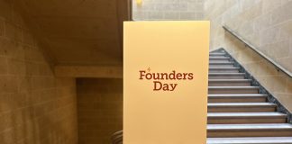 Large white sign on an easel that reads, "Founders Day"