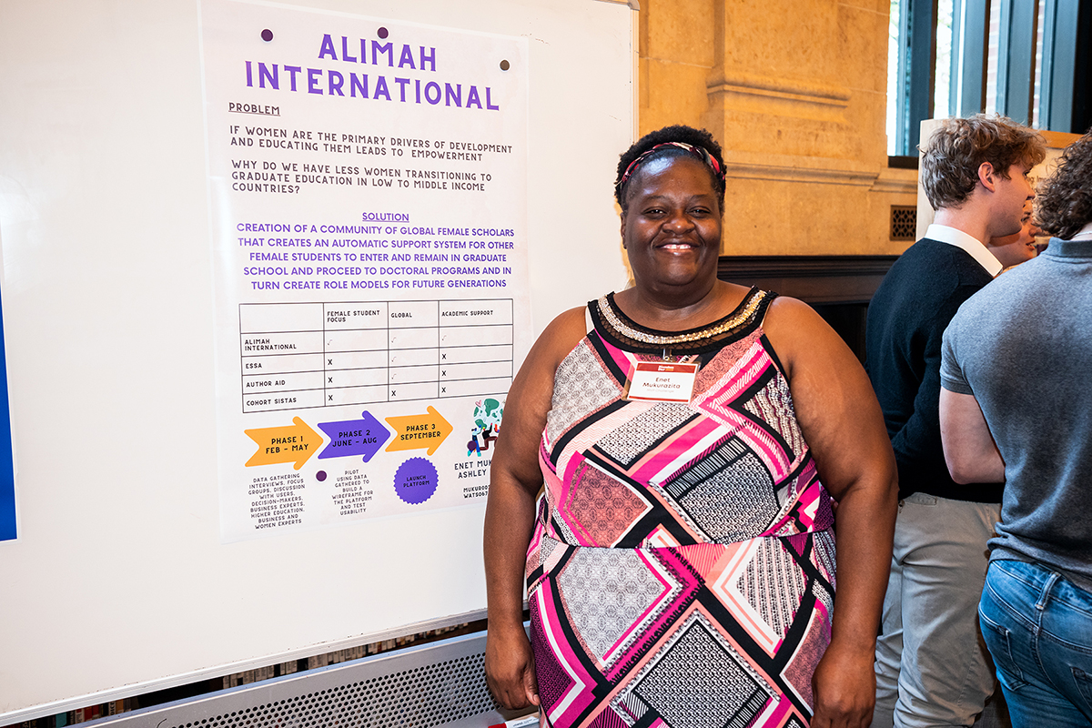 Enet standing in front of her Alimah International poster at Founders Day.