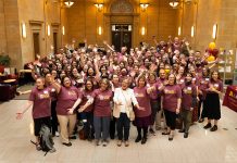 Group portrait of all the attendees wearing identical maroon T-shirts at the Walter Library at 100: An Afternoon Tea celebration