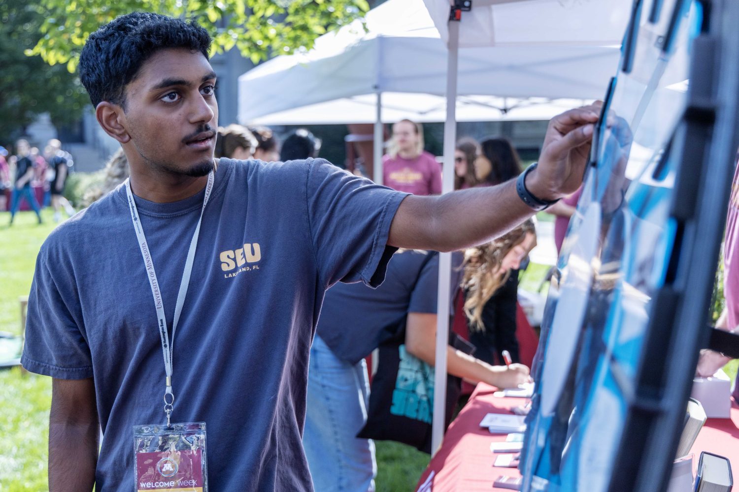 Students spin the wheel for a challenge and prize at the Libraries' table for Welcome Week. (Photo/Adria Carpenter)